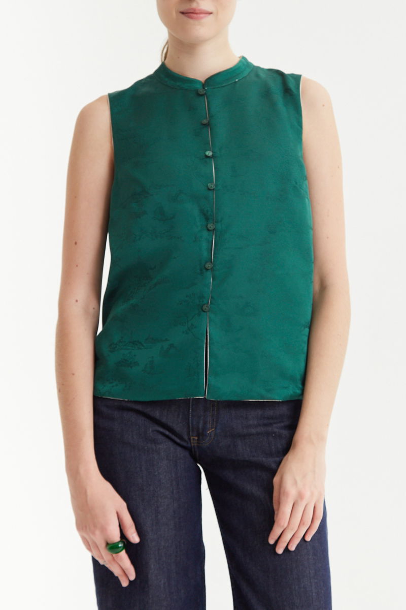 Blusa cruda reversible de jacquard satinado sin mangas con cuello mao, botones a tono, pinzas frontales y aberturas laterales.