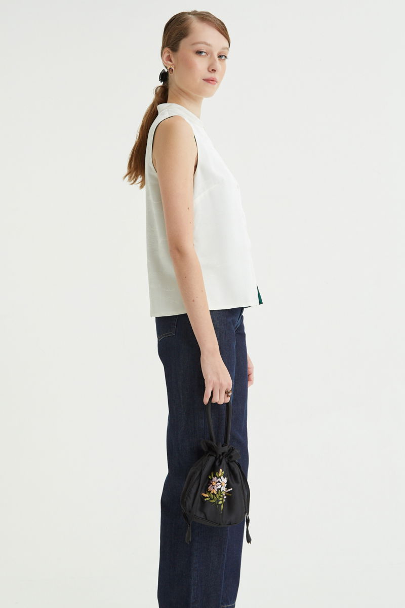 Blusa cruda reversible de jacquard satinado sin mangas con cuello mao, botones a tono, pinzas frontales y aberturas laterales.