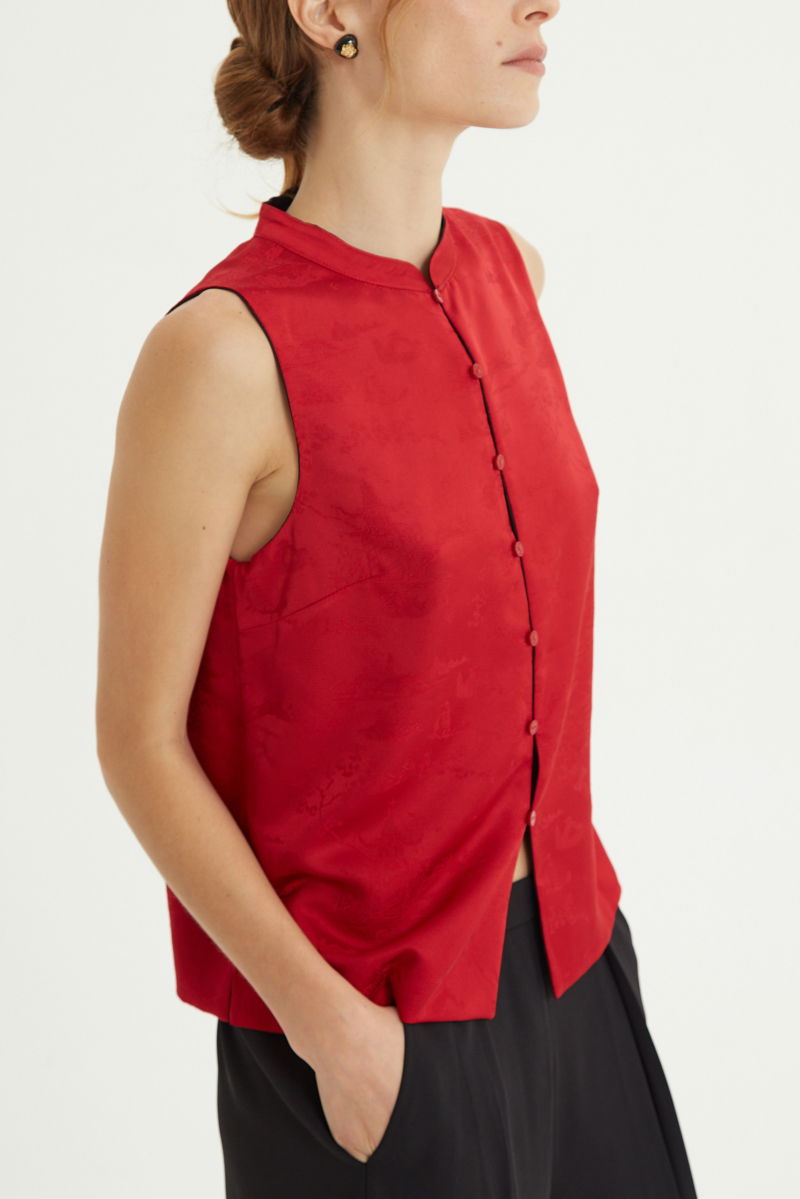 Blusa negra reversible de jacquard satinado sin mangas con cuello mao, botones a tono, pinzas frontales y aberturas laterales.