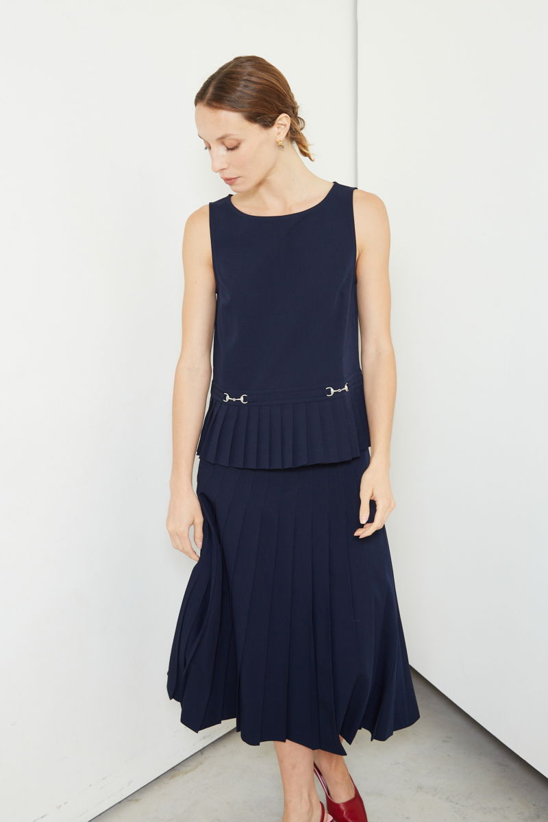 Falda azul sastrera midi de corte evasé y tiro alto con herrajes metálicos en la cintura. 