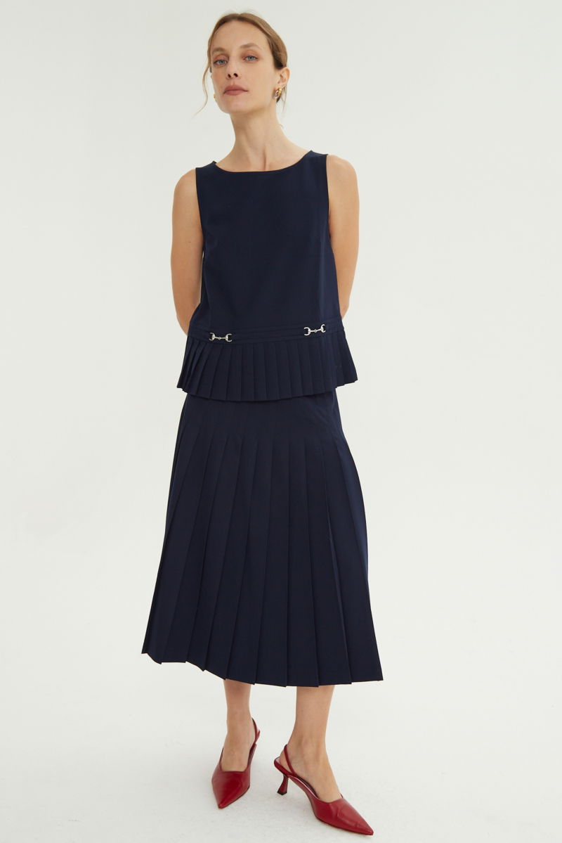 Falda azul sastrera midi de corte evasé y tiro alto con herrajes metálicos en la cintura. 