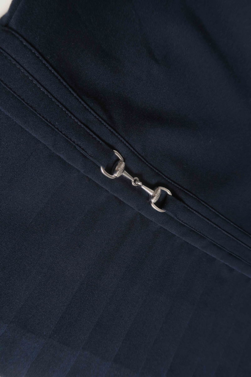 Blusa azul sastrera sin mangas con tablas en la cintura, herrajes metálicos y escote a la base del cuello, larga a la cadera. 