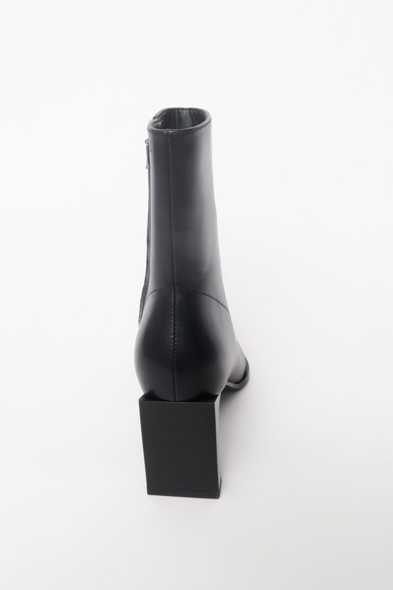 Botas de cuero de caña media en punta con taco rectangular de 7 cm y cierre lateral oculto. 
