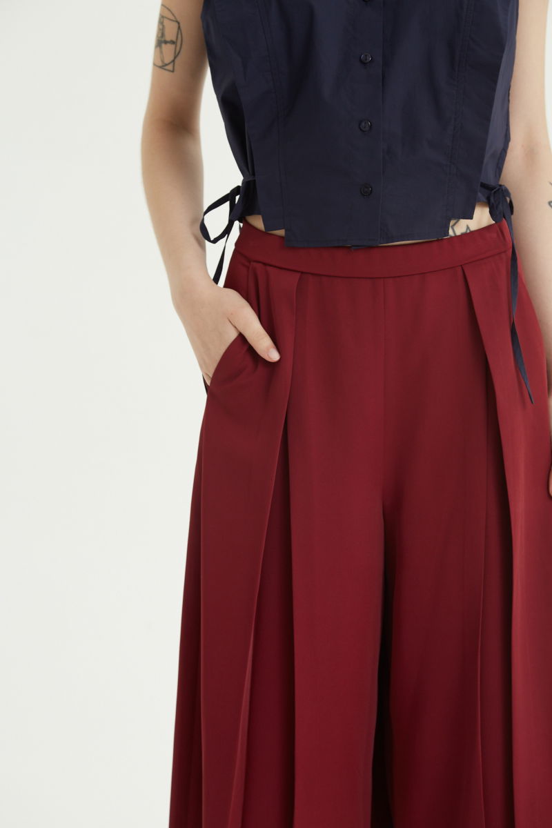 Bermuda bordo sastrera tiro medio con piernas anchas hasta la rodilla, cintura trasera con elástico, tablas y bolsillos laterales. 