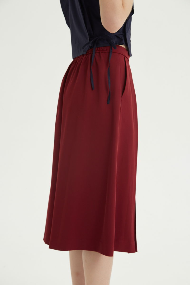 Bermuda bordo sastrera tiro medio con piernas anchas hasta la rodilla, cintura trasera con elástico, tablas y bolsillos laterales. 