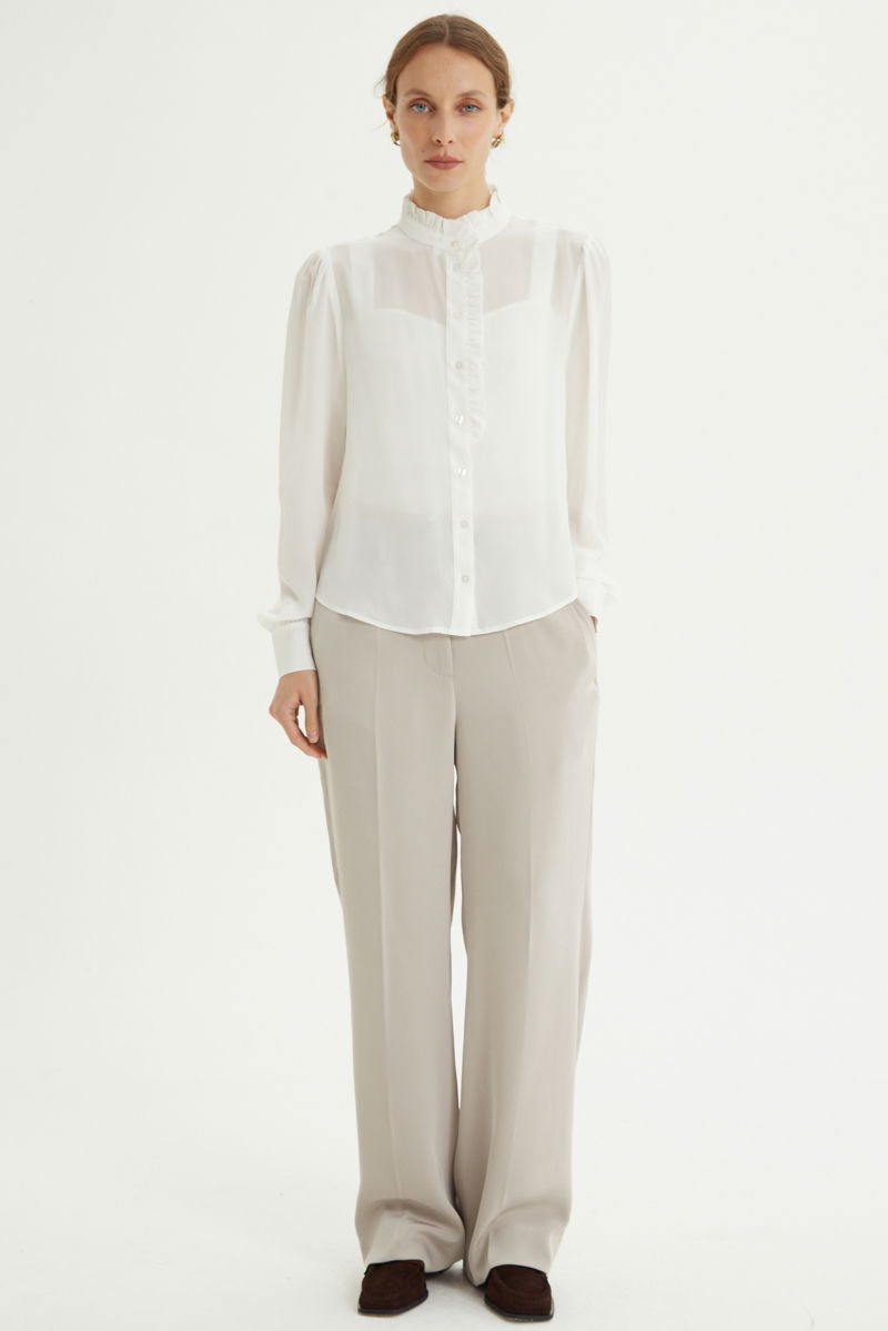 Pantalón beige sastrero tiro alto recto y largo a los tobillos con cintura con elástico y lazo a tono para atar. 