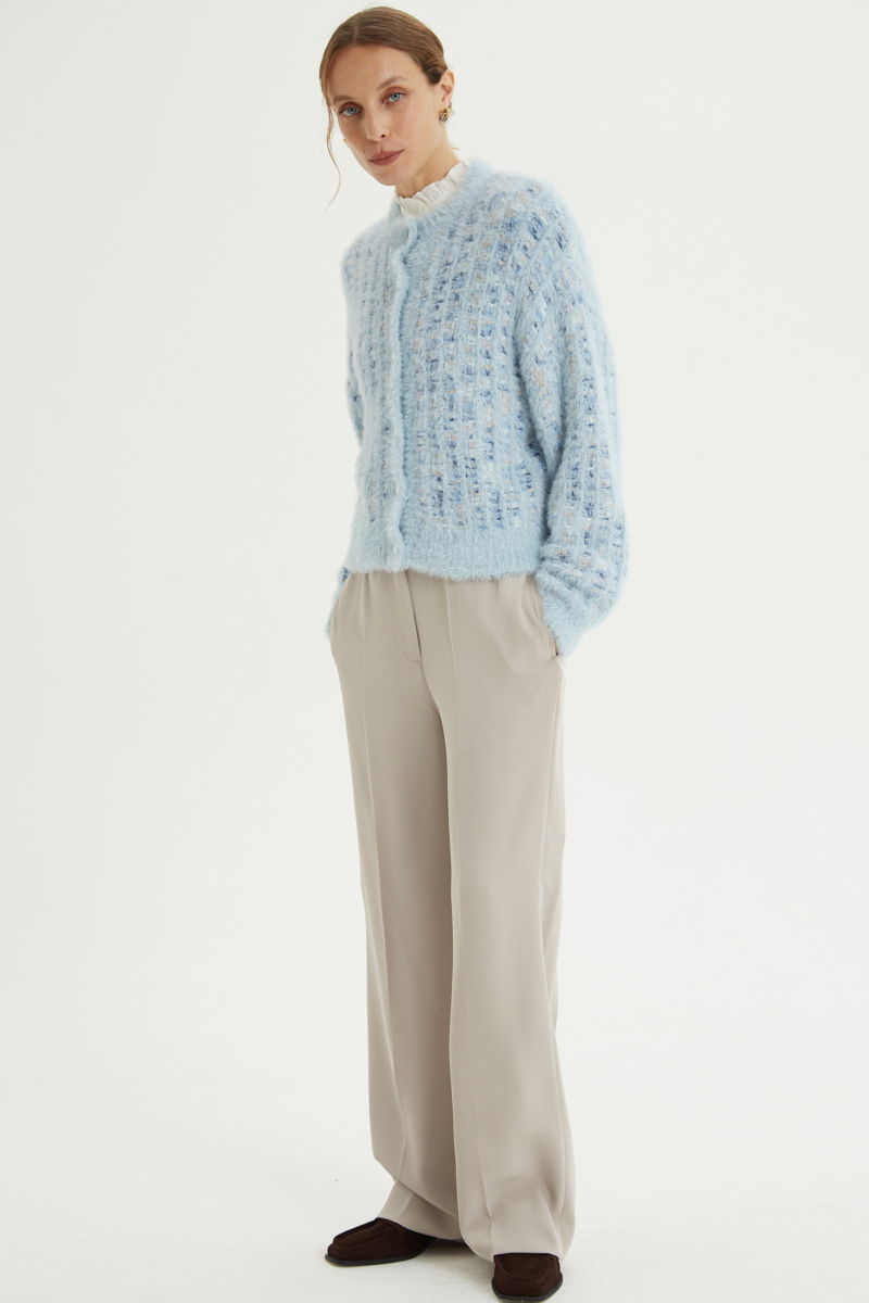 Saco tejido multicolor con textura de pelo y botones perlados en forma de flor. 
