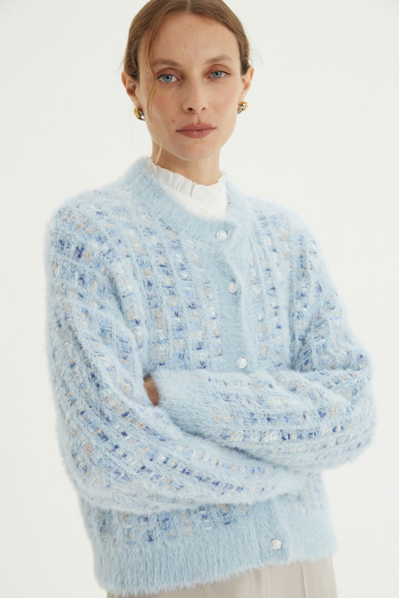 Saco tejido multicolor con textura de pelo y botones perlados en forma de flor. 
