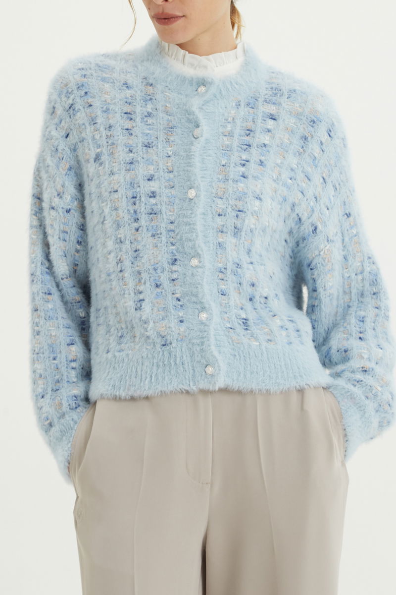 Saco tejido multicolor con textura de pelo y botones perlados en forma de flor. 
