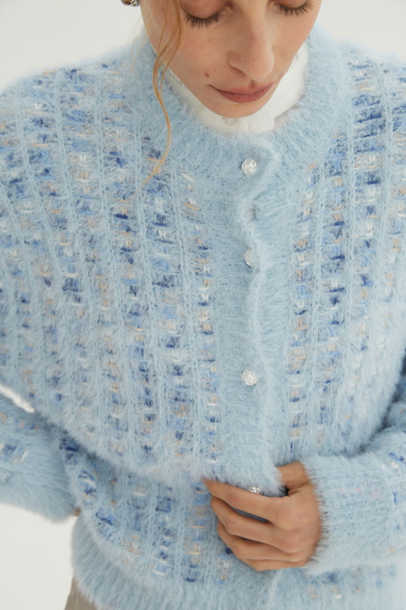 Saco tejido multicolor con textura de pelo y botones perlados en forma de flor. 
