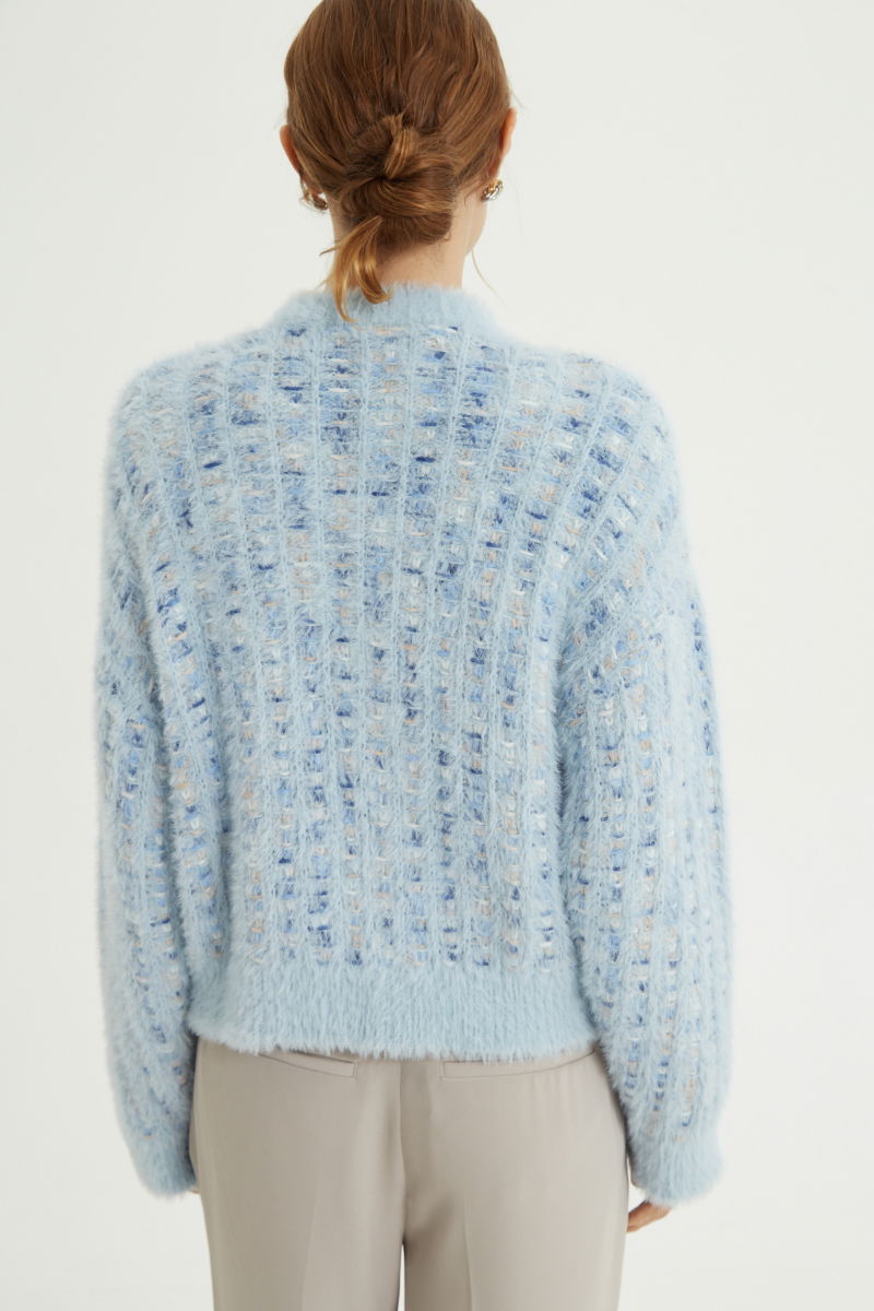 Saco tejido multicolor con textura de pelo y botones perlados en forma de flor. 
