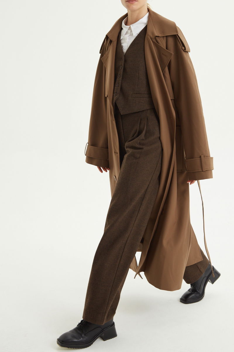 Trench sastrero largo con solapas amplias, charreteras en los hombros y cinturón.  
