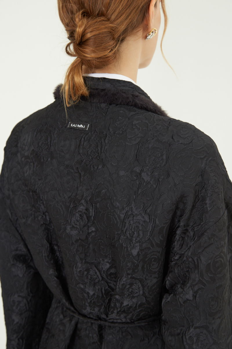 Tapado de brocato con textura de rosas y terminación de pelo en cuello y puños, recto y amplio con mangas anchas y lazo para ajustar. 