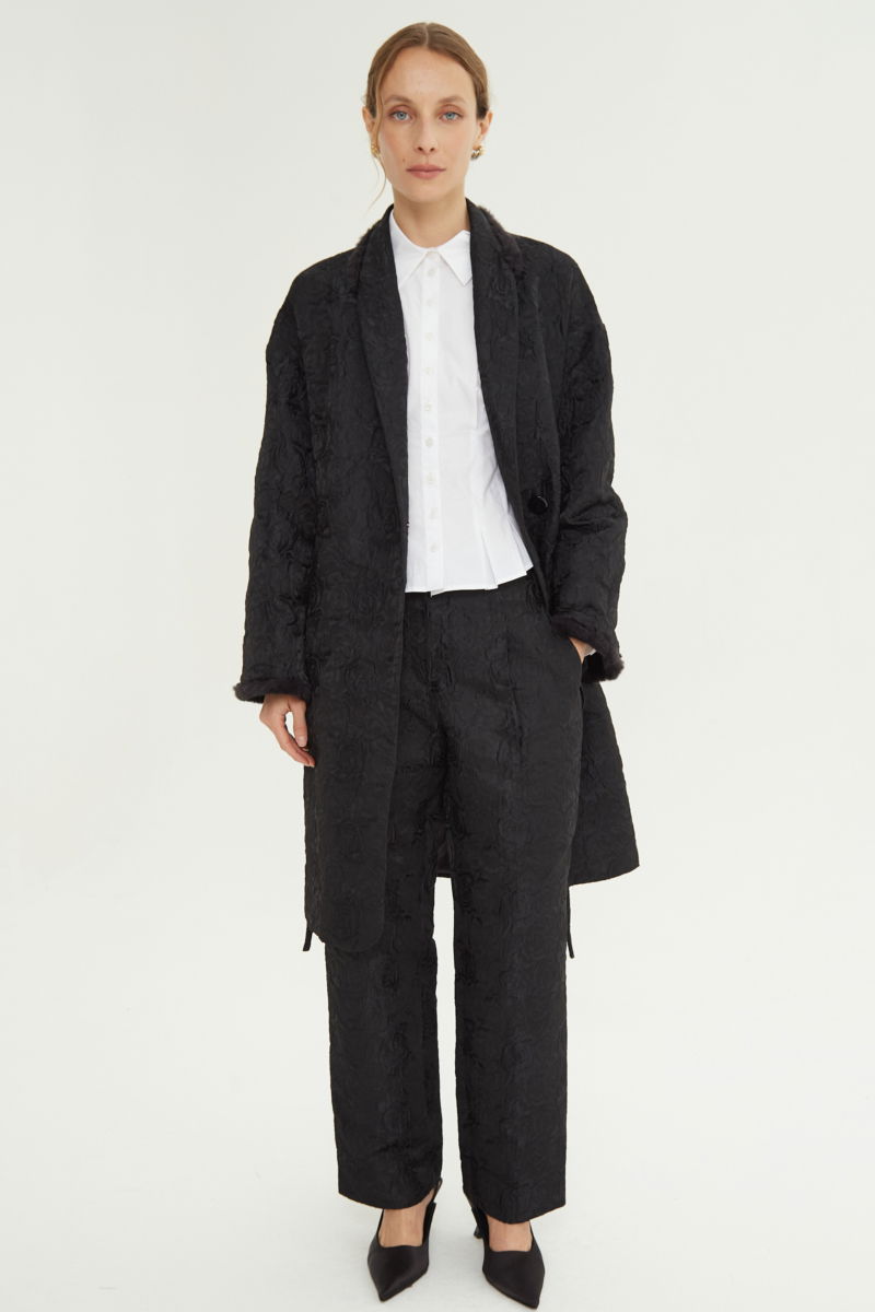 Tapado de brocato con textura de rosas y terminación de pelo en cuello y puños, recto y amplio con mangas anchas y lazo para ajustar. 