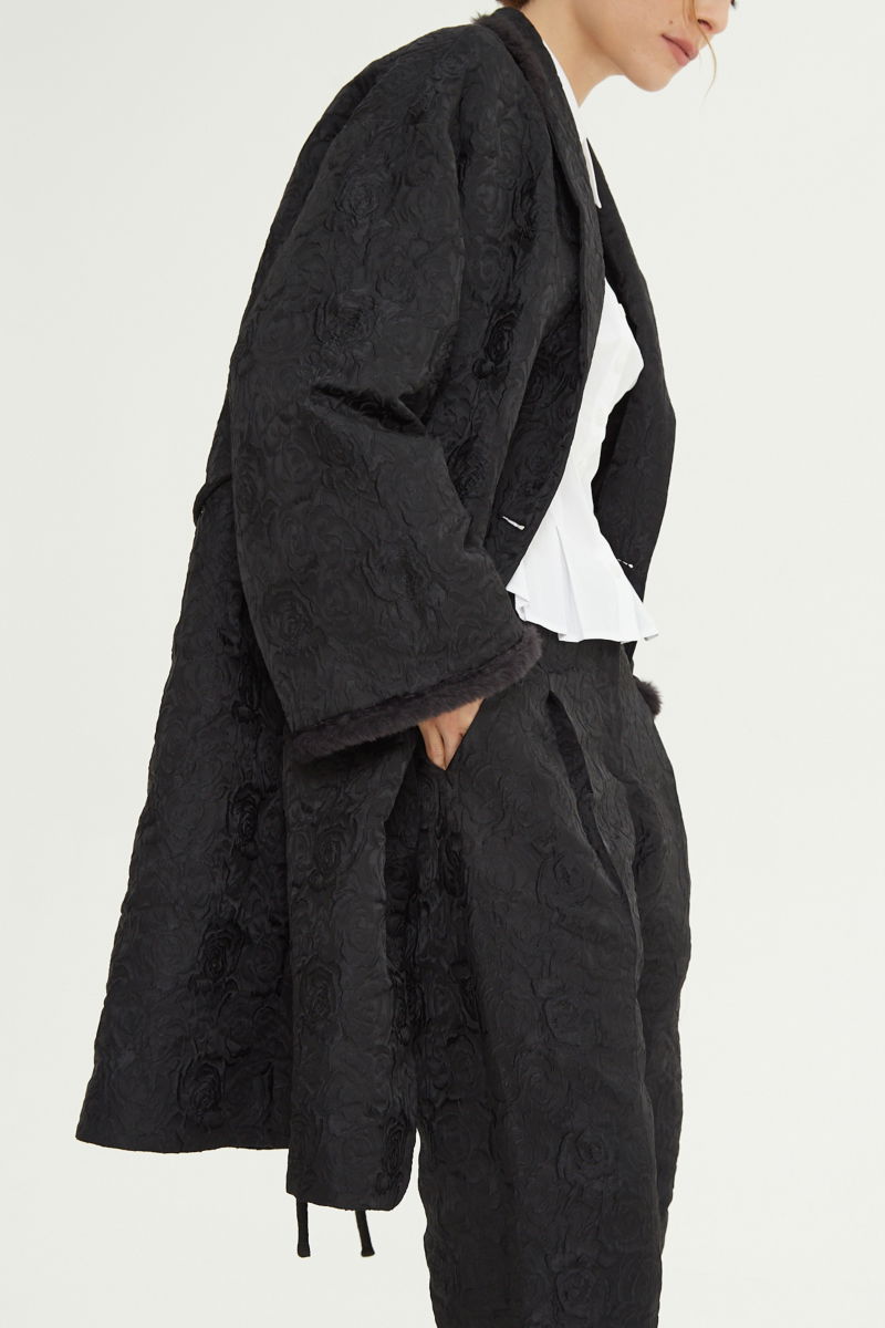 Tapado de brocato con textura de rosas y terminación de pelo en cuello y puños, recto y amplio con mangas anchas y lazo para ajustar. 