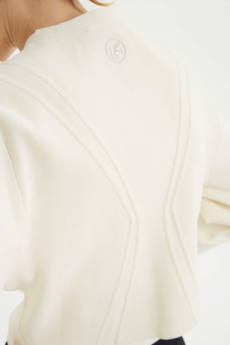 Campera crudo tejida estilo bomber larga a la cadera con cierre doble camino, cuello mao con broche snap, hombros anchos y terminación redondeada en el ruedo.