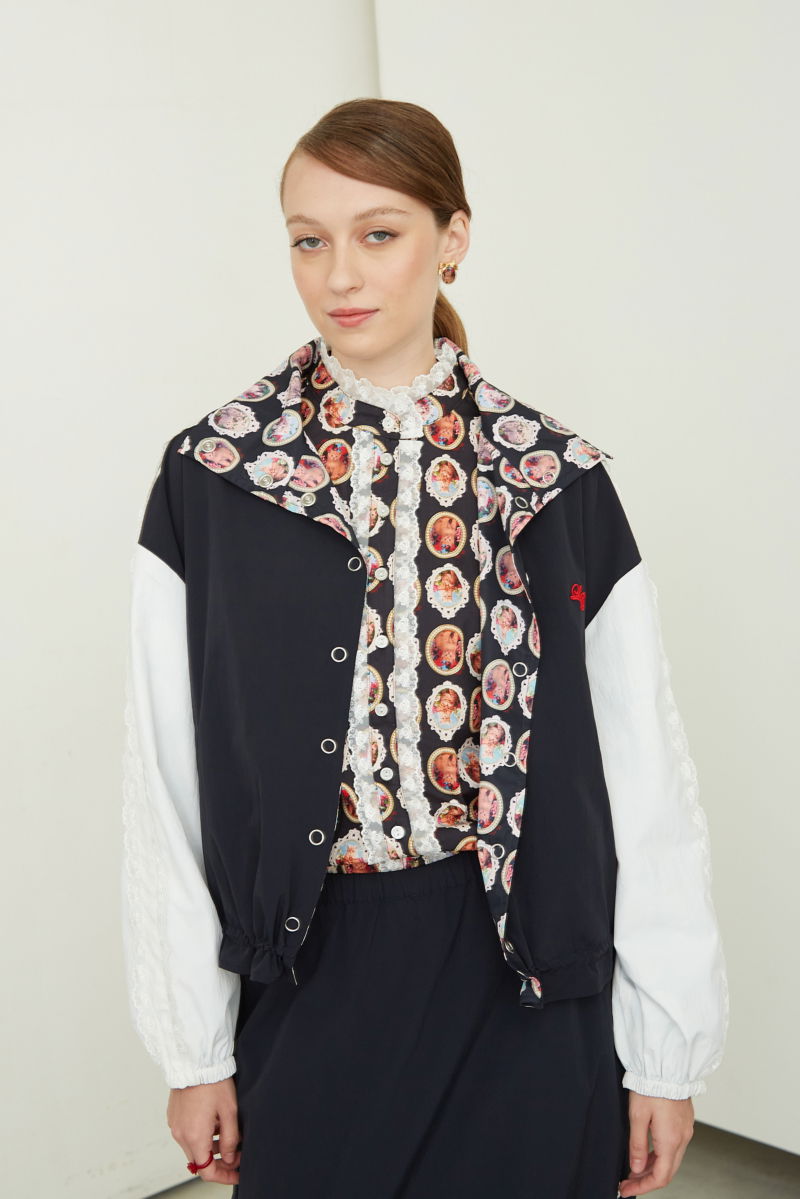 Campera reversible con puntilla y estampado de gatitos, cuello alto, broches snap y cintura con tancas.