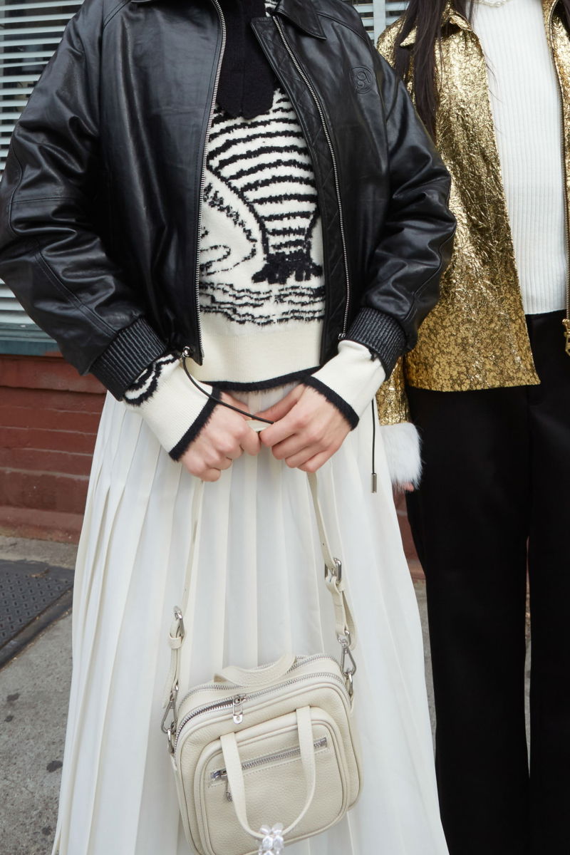 Falda cruda sastrera midi de corte evasé y tiro alto con herrajes metálicos en la cintura. 
