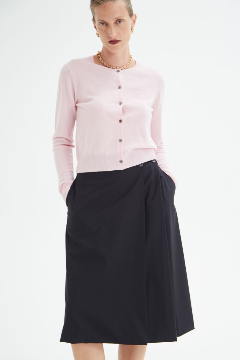 Cardigan rosa de lana y cachemira de corte recto entallado en la cintura con terminaciones en rib en puños y ruedo, cuello redondo cerrado y botones a tono.