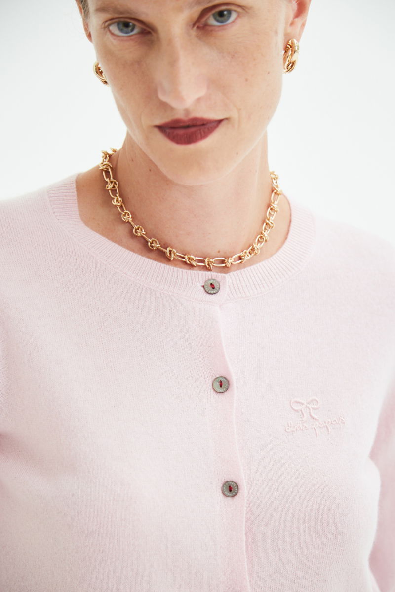 Cardigan rosa de lana y cachemira de corte recto entallado en la cintura con terminaciones en rib en puños y ruedo, cuello redondo cerrado y botones a tono.