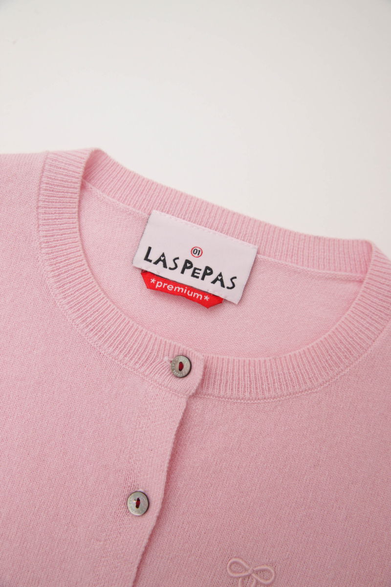 Cardigan rosa de lana y cachemira de corte recto entallado en la cintura con terminaciones en rib en puños y ruedo, cuello redondo cerrado y botones a tono.