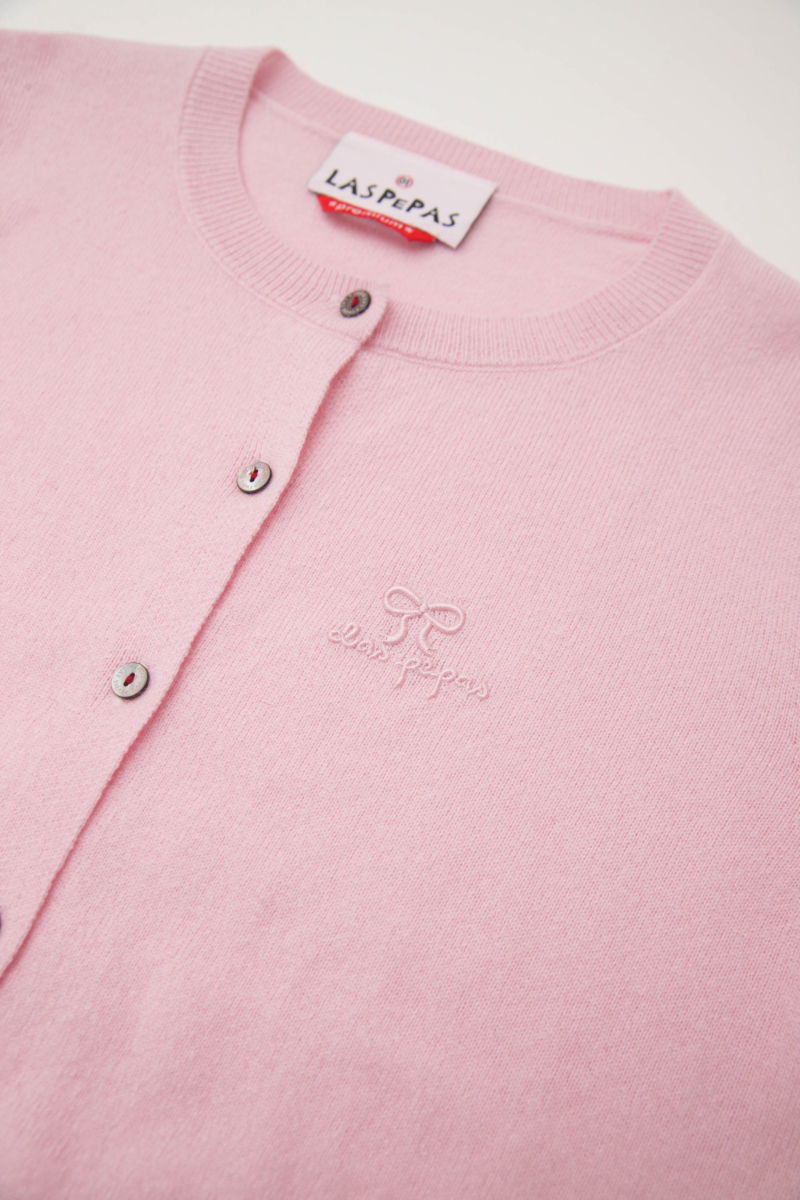 Cardigan rosa de lana y cachemira de corte recto entallado en la cintura con terminaciones en rib en puños y ruedo, cuello redondo cerrado y botones a tono.