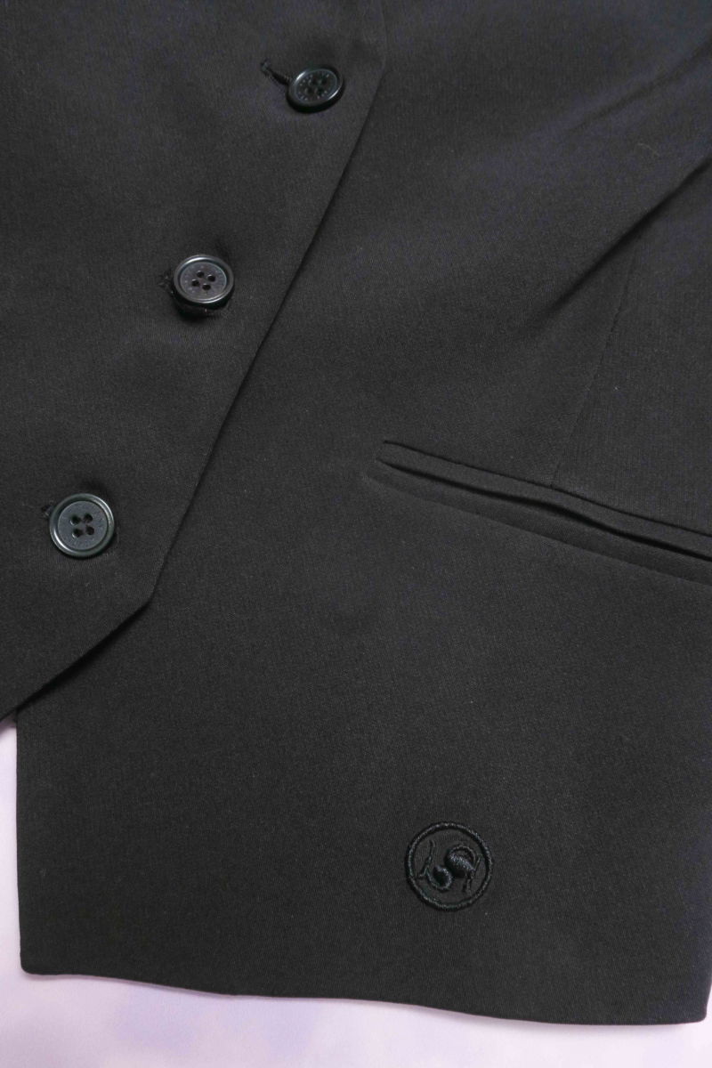 Chaleco negro sastrero largo a la cadera con botones a tono, bolsillos ojal y pinzas en frente y espalda. 
