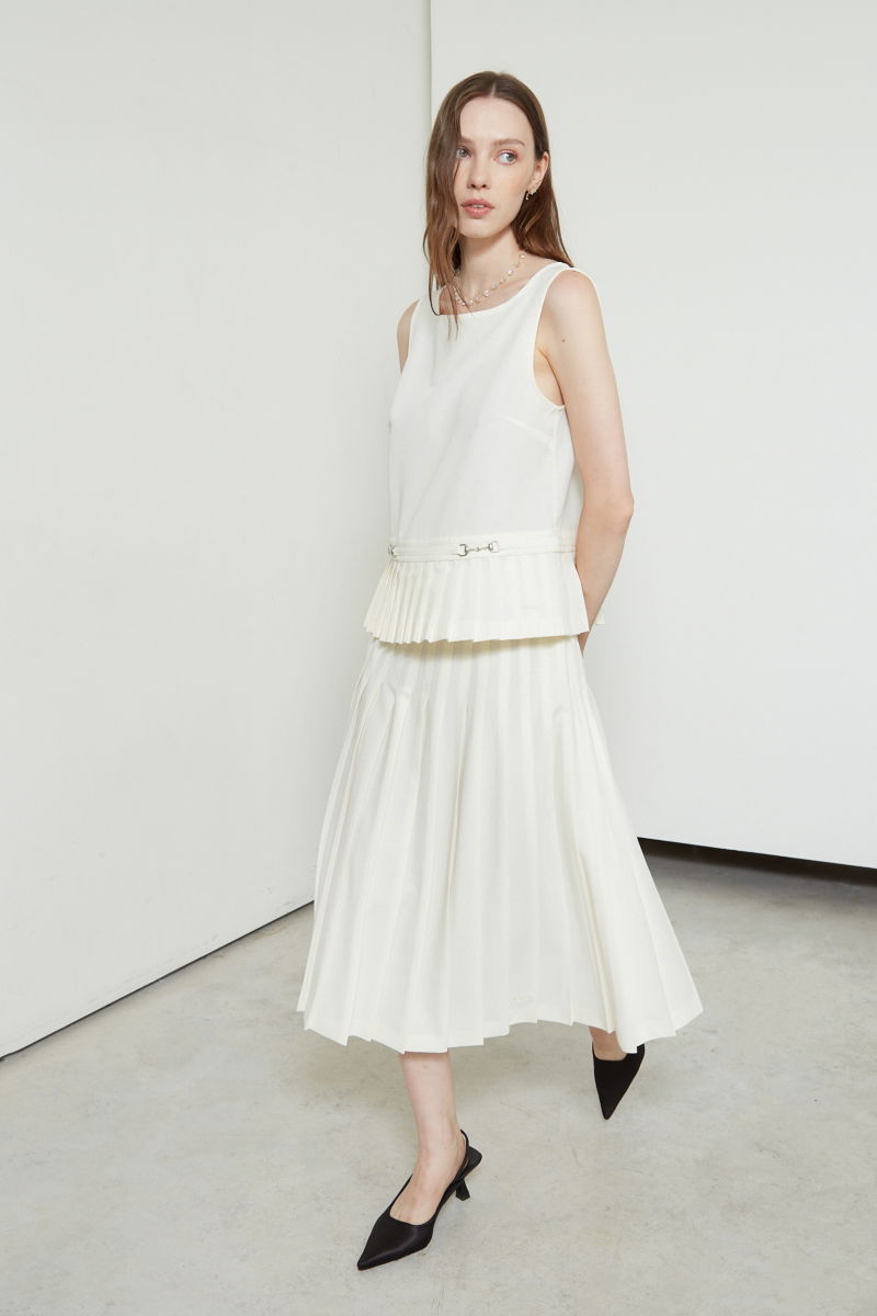 Falda cruda sastrera midi de corte evasé y tiro alto con herrajes metálicos en la cintura. 
