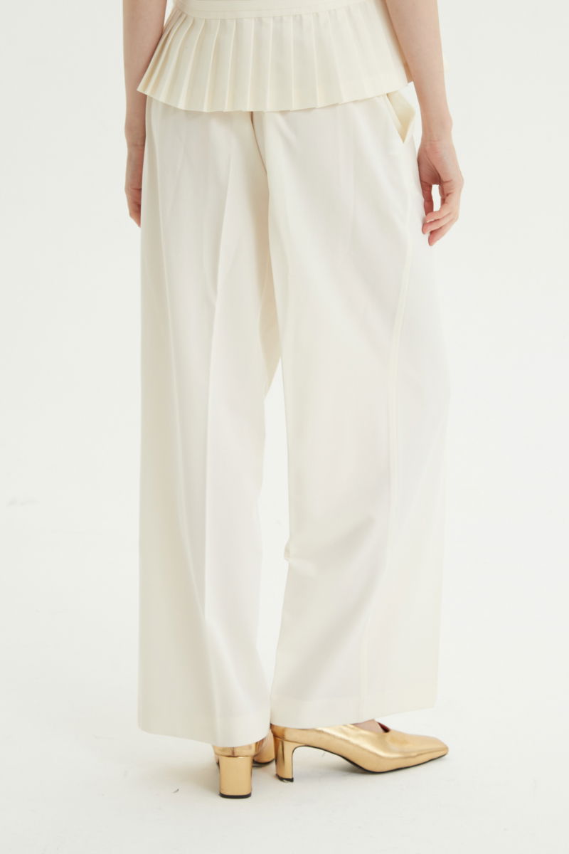 Pantalón crudo sastrero tiro alto y recto con herrajes metálicos, pliegue en las piernas y elástico en la cintura trasera. 
