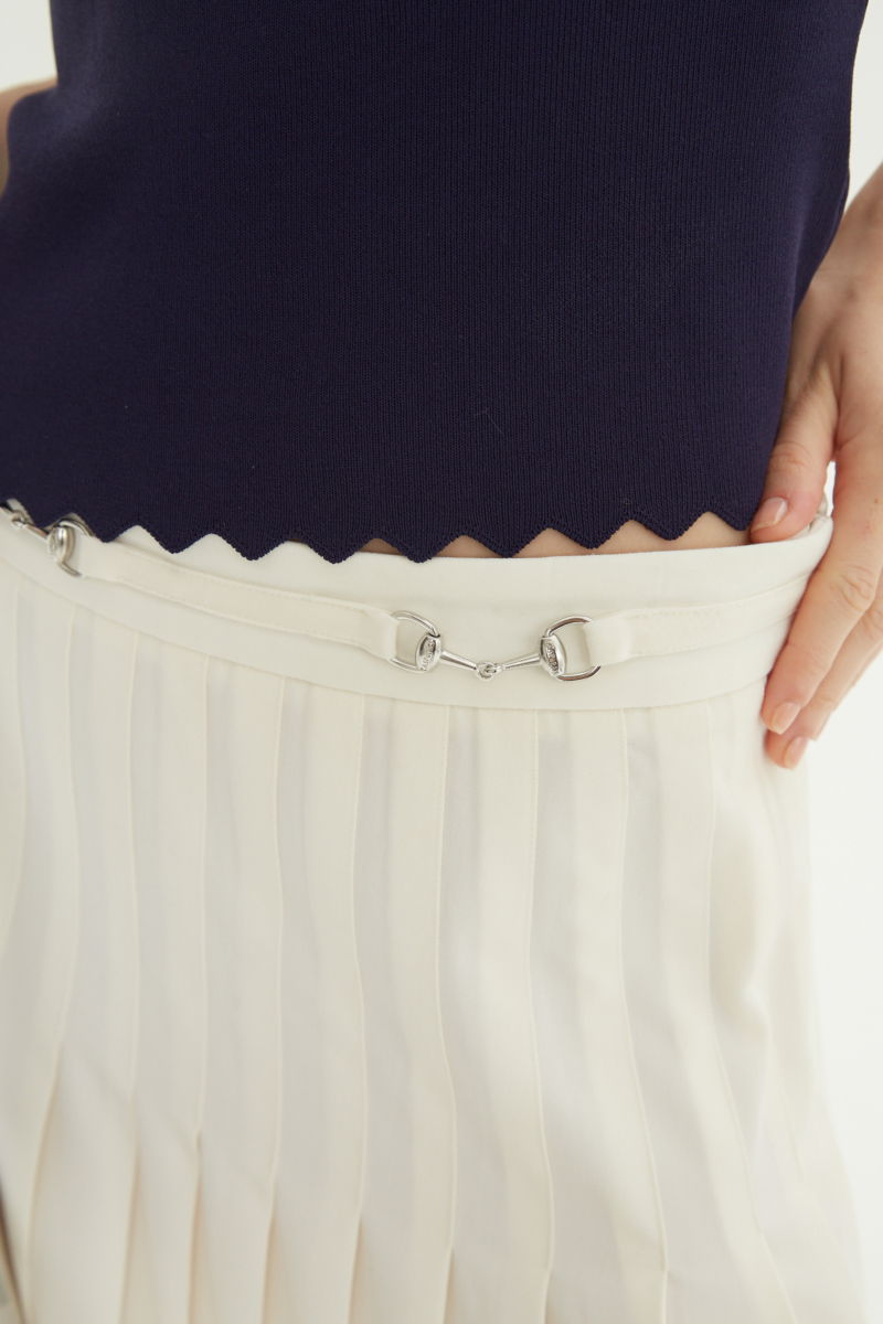 Falda cruda sastrera midi de corte evasé y tiro alto con herrajes metálicos en la cintura. 
