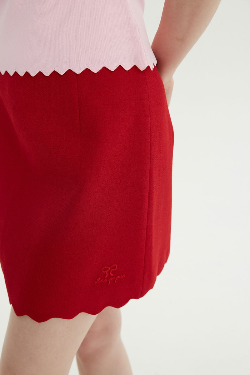 Mini falda rojo sastrera tiro medio de silueta recta con terminación ondulada en el ruedo. 
