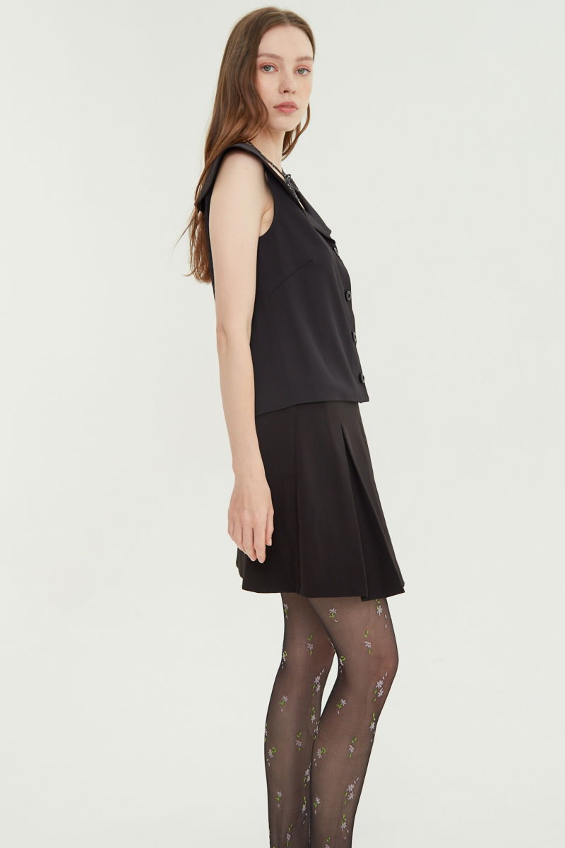 Falda negra sastrera acampanada con sobre falda tableada con lazo para atar en el lateral. 