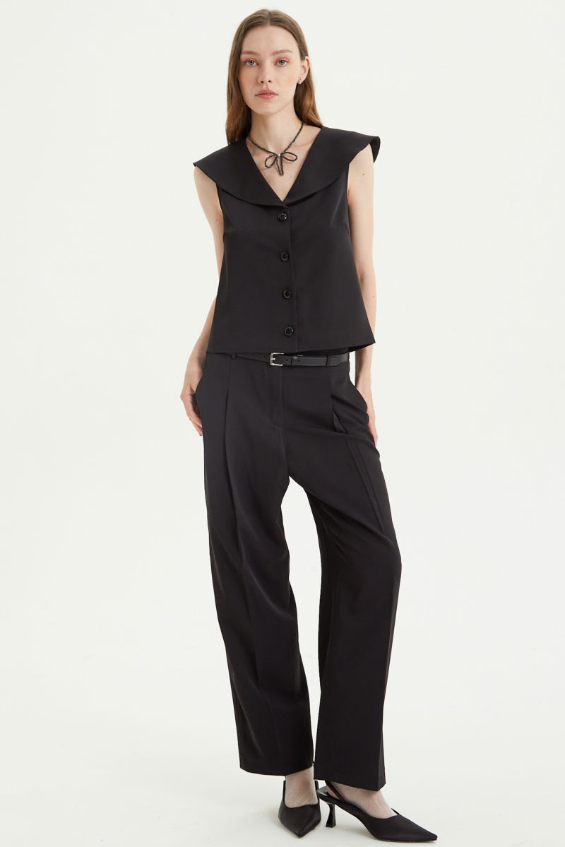 Pantalón negro sastrero tiro alto, de corte recto y largo hasta los tobillos con pinzas de entalle en frente y espalda. 