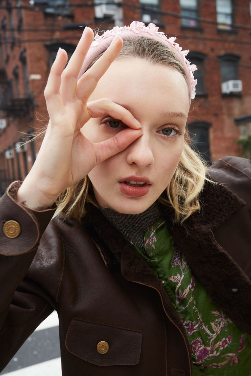 Campera de cuero marron con interior de pelo afelpado, recta y larga a la cadera con botones chatos metalicos y solapas frontales que simulan ser bolsillos. 
