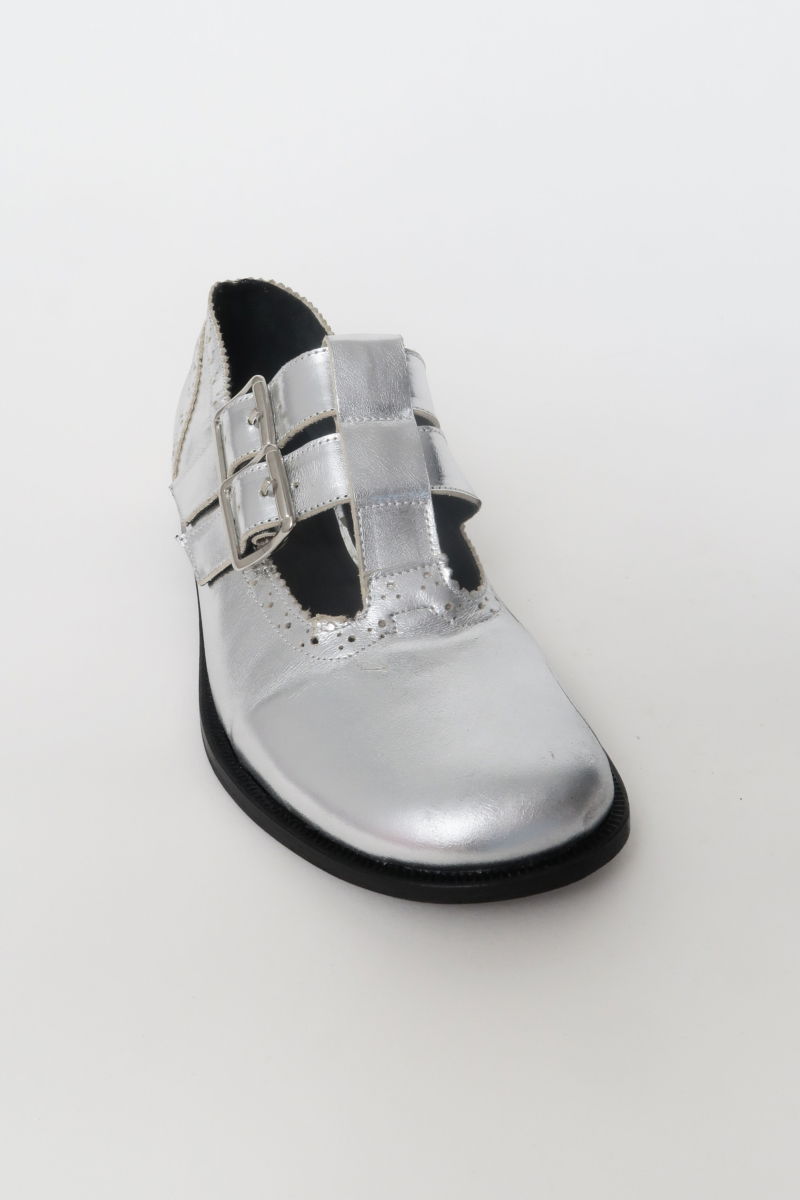 Guillermina de cuero metalizado con punta redonda y taco de 2 cm, con dos tiras ajustables con hebillas metálicas, detalles de zigzag y picado y vira marcada. 