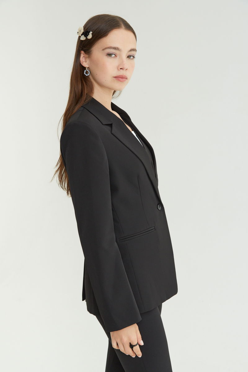 Blazer negro sastrero recto con hombreras, bolsillos ojal y pinzas en frente y espalda. 
