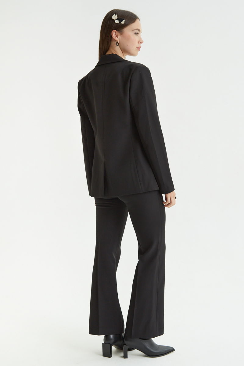 Blazer negro sastrero recto con hombreras, bolsillos ojal y pinzas en frente y espalda. 
