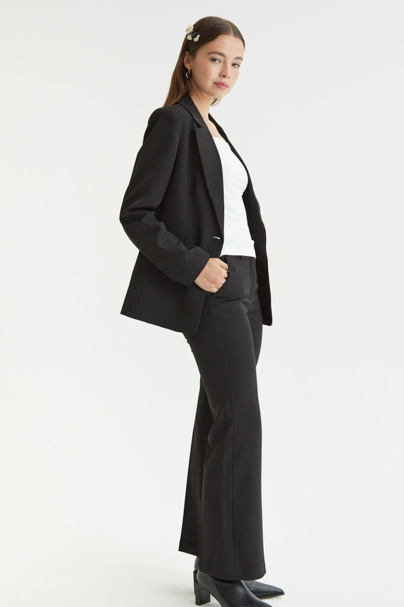 Blazer negro sastrero recto con hombreras, bolsillos ojal y pinzas en frente y espalda. 
