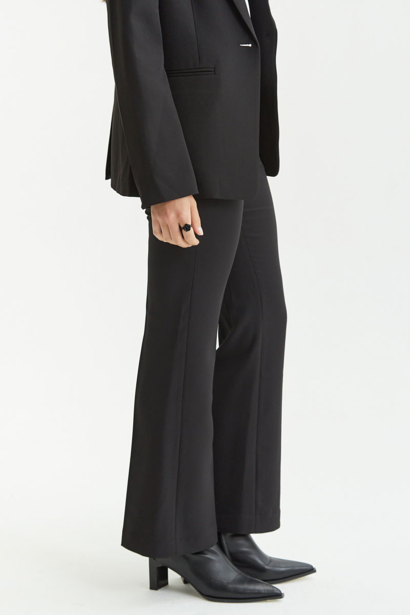 Pantalón negro sastrero tiro alto de corte recto y largo al tobillo con pinzas en el frente, bolsillos laterales y bolsillo ojal en la espalda. 
