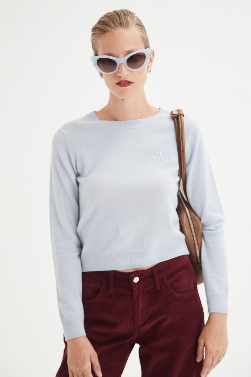 Sweater celeste de lana y cachemira recto y entallado en la cintura con cuello redondo y terminaciones de ribb en puños y ruedo.