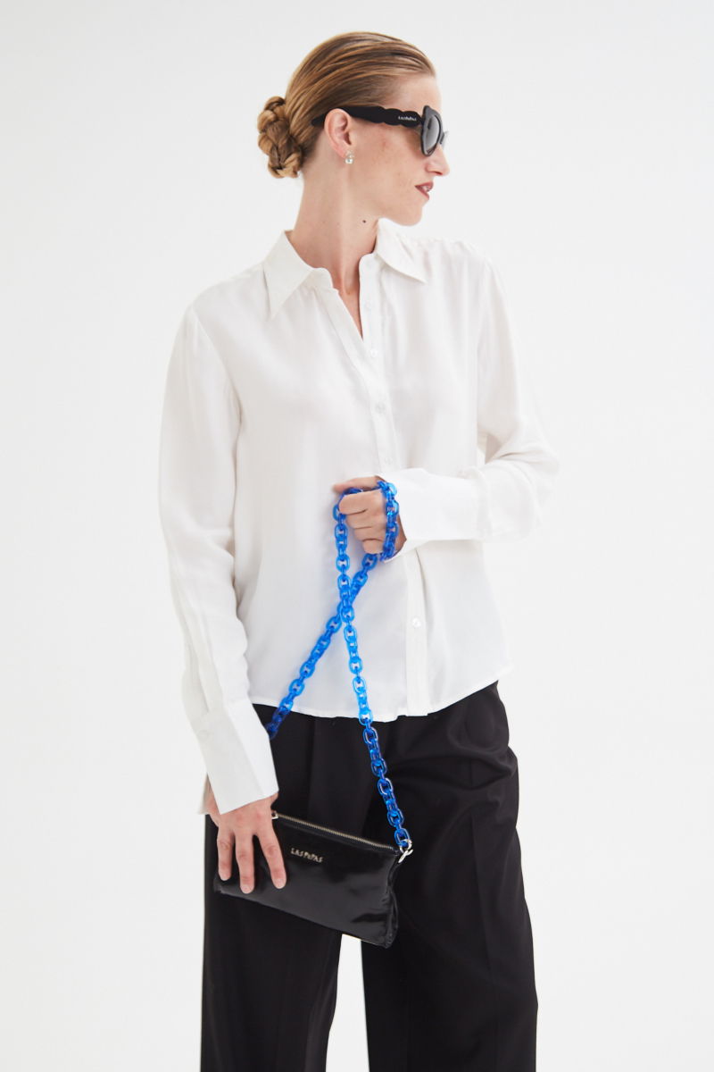 Camisa blanca de calce recto y puños anchos con textura suave de piel de durazno. 
