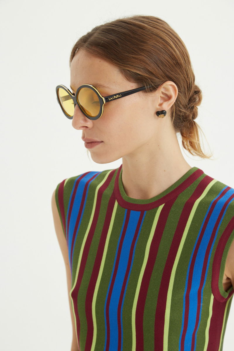 Musculosa verde tejida a rayas de cuello redondo, calce recto y larga hasta la cadera con aberturas laterales.