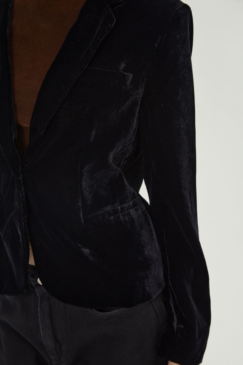 Blazer negro sastrero con hombreras de corte recto con pinzas de entalle y largo hasta la cadera.