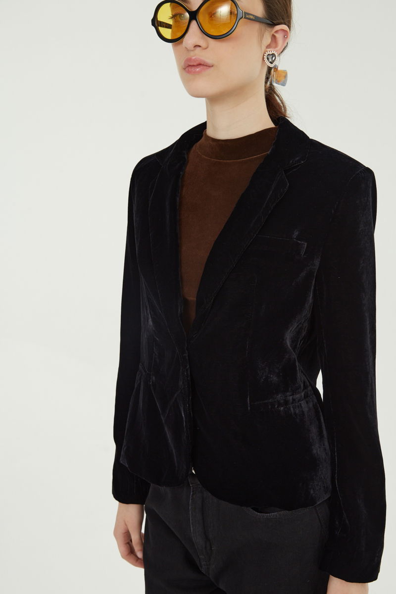 Blazer negro sastrero con hombreras de corte recto con pinzas de entalle y largo hasta la cadera.