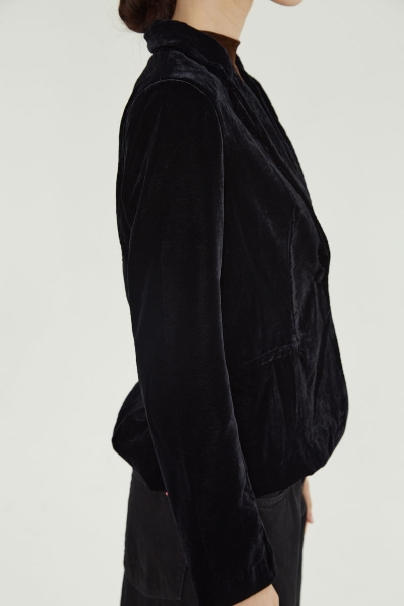 Blazer negro sastrero con hombreras de corte recto con pinzas de entalle y largo hasta la cadera.