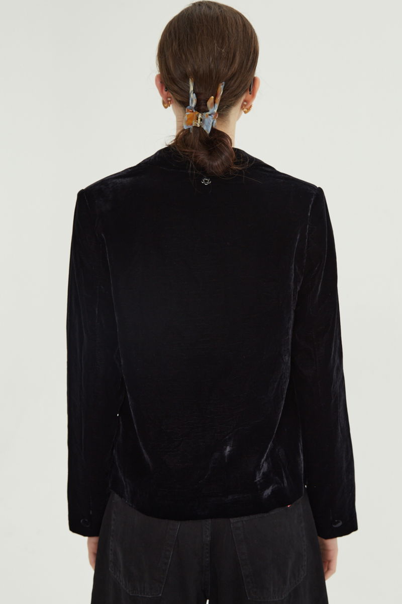 Blazer negro sastrero con hombreras de corte recto con pinzas de entalle y largo hasta la cadera.