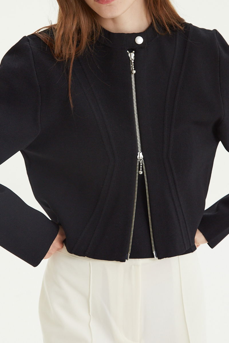 Campera negra tejida estilo bomber larga a la cadera con cierre doble camino, cuello mao con broche snap, hombros anchos y terminación redondeada en el ruedo.