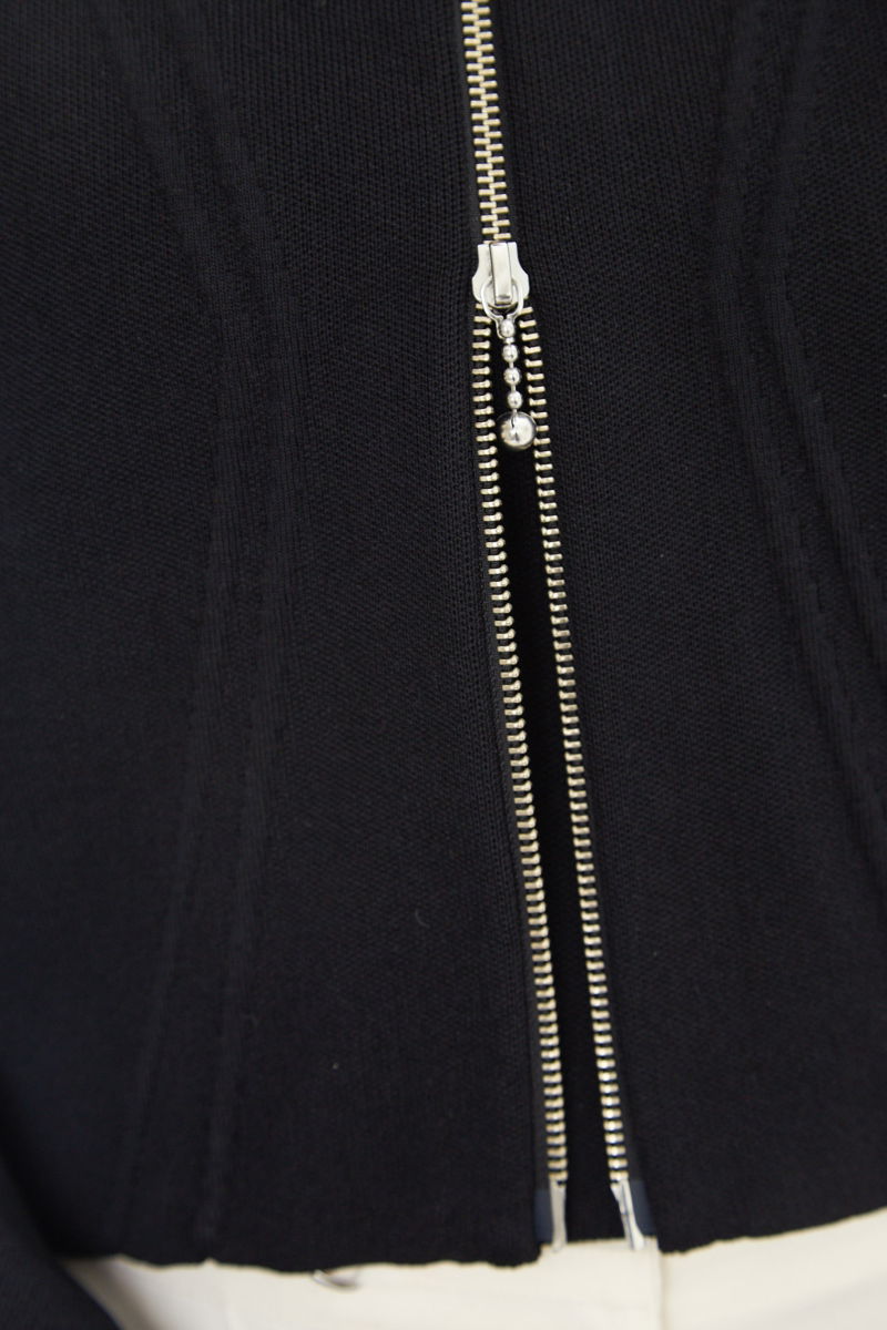 Campera negra tejida estilo bomber larga a la cadera con cierre doble camino, cuello mao con broche snap, hombros anchos y terminación redondeada en el ruedo.