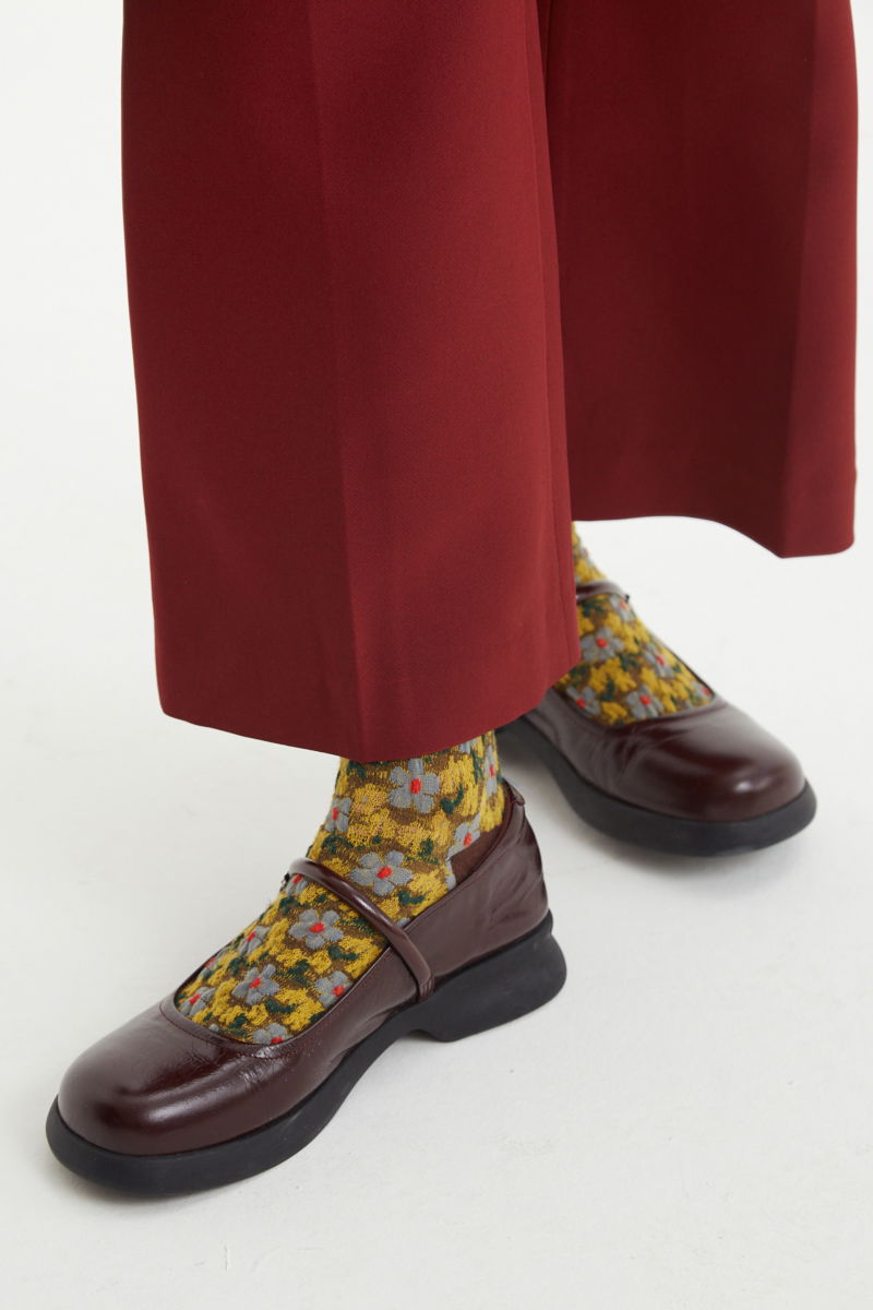 Guillermina bordo de cuero con punta redonda, hebilla con forma de flor y plataforma de caucho.