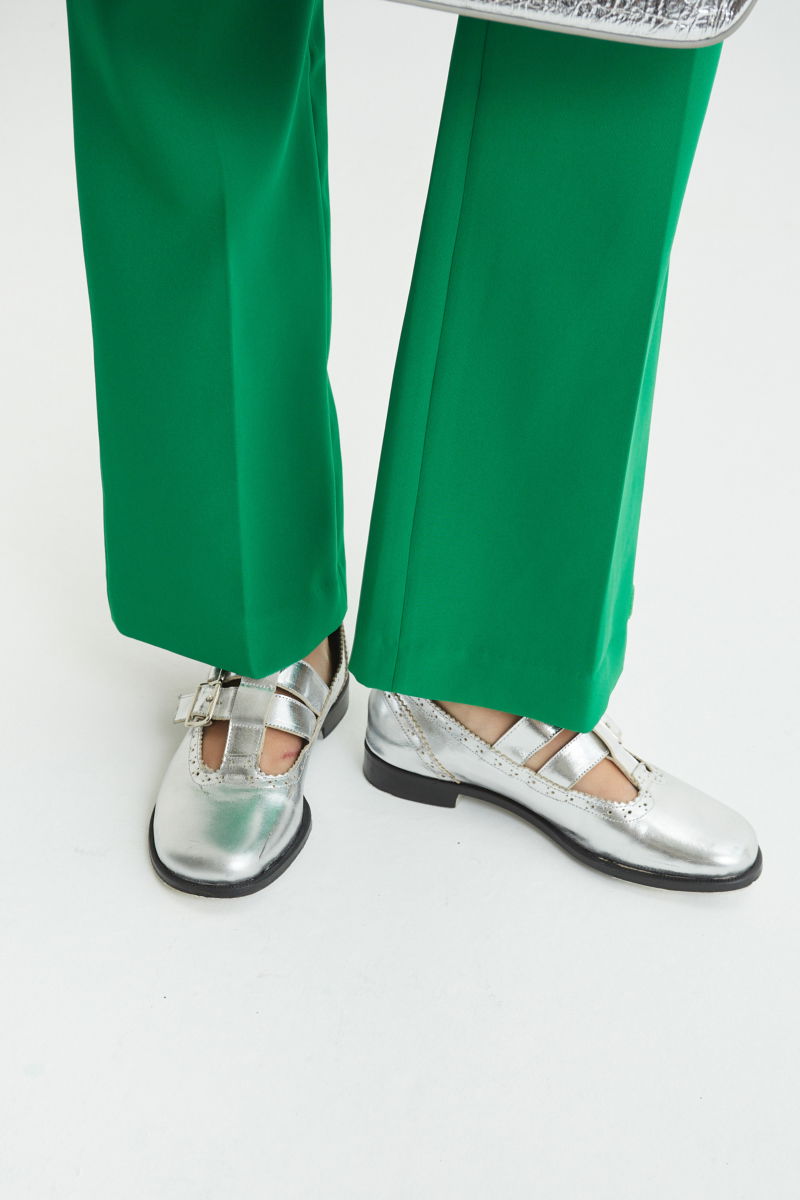 Guillermina de cuero metalizado con punta redonda y taco de 2 cm, con dos tiras ajustables con hebillas metálicas, detalles de zigzag y picado y vira marcada. 